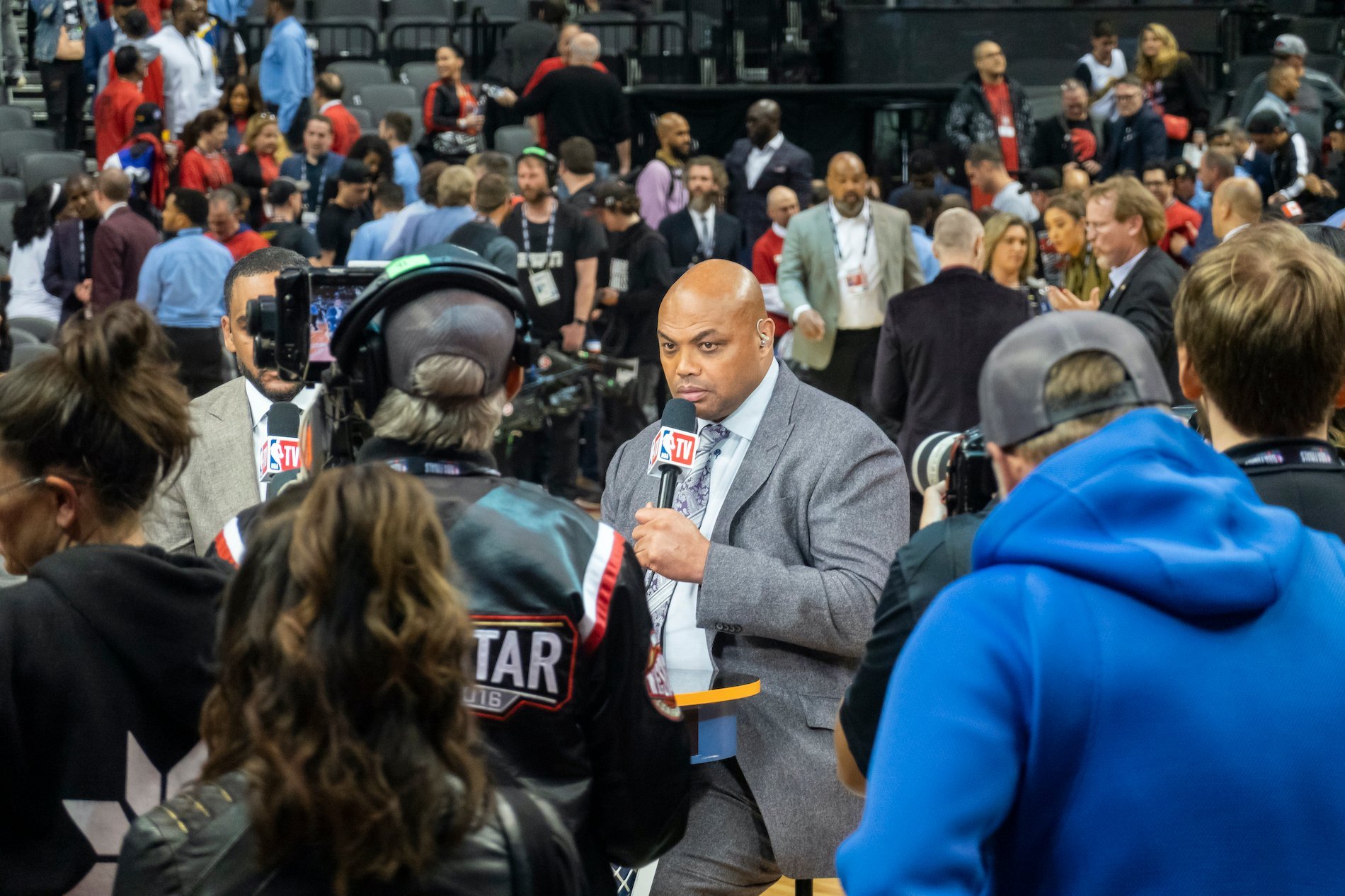 Charles Barkley holds a microphone surrounded by a crowd